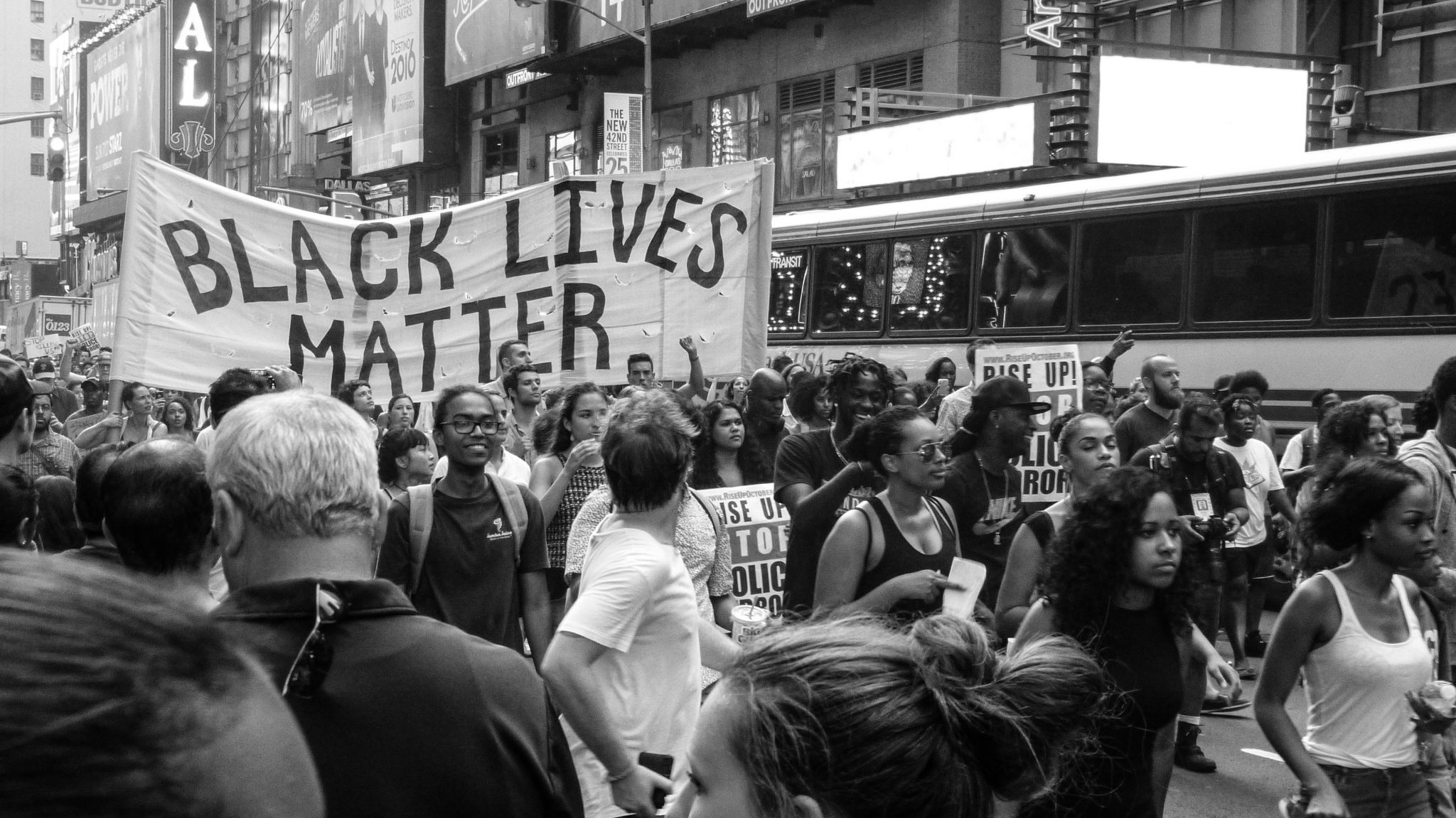 Black and white image of a protest, with a sign reading "Black Lives Matter"