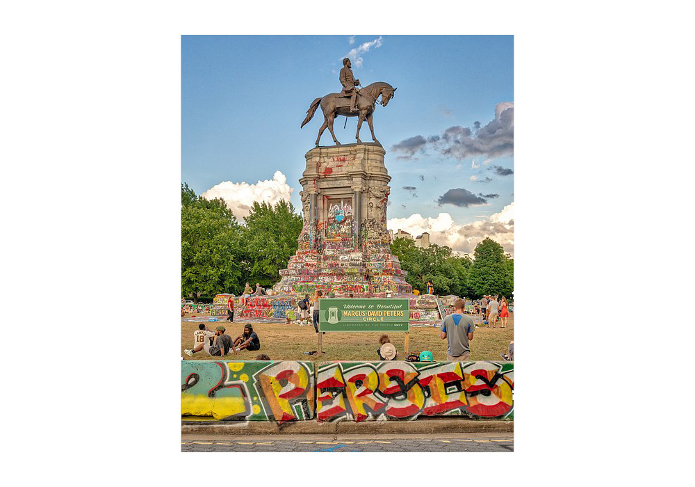A statue of a man on a horse, the base is covered in graffiti
