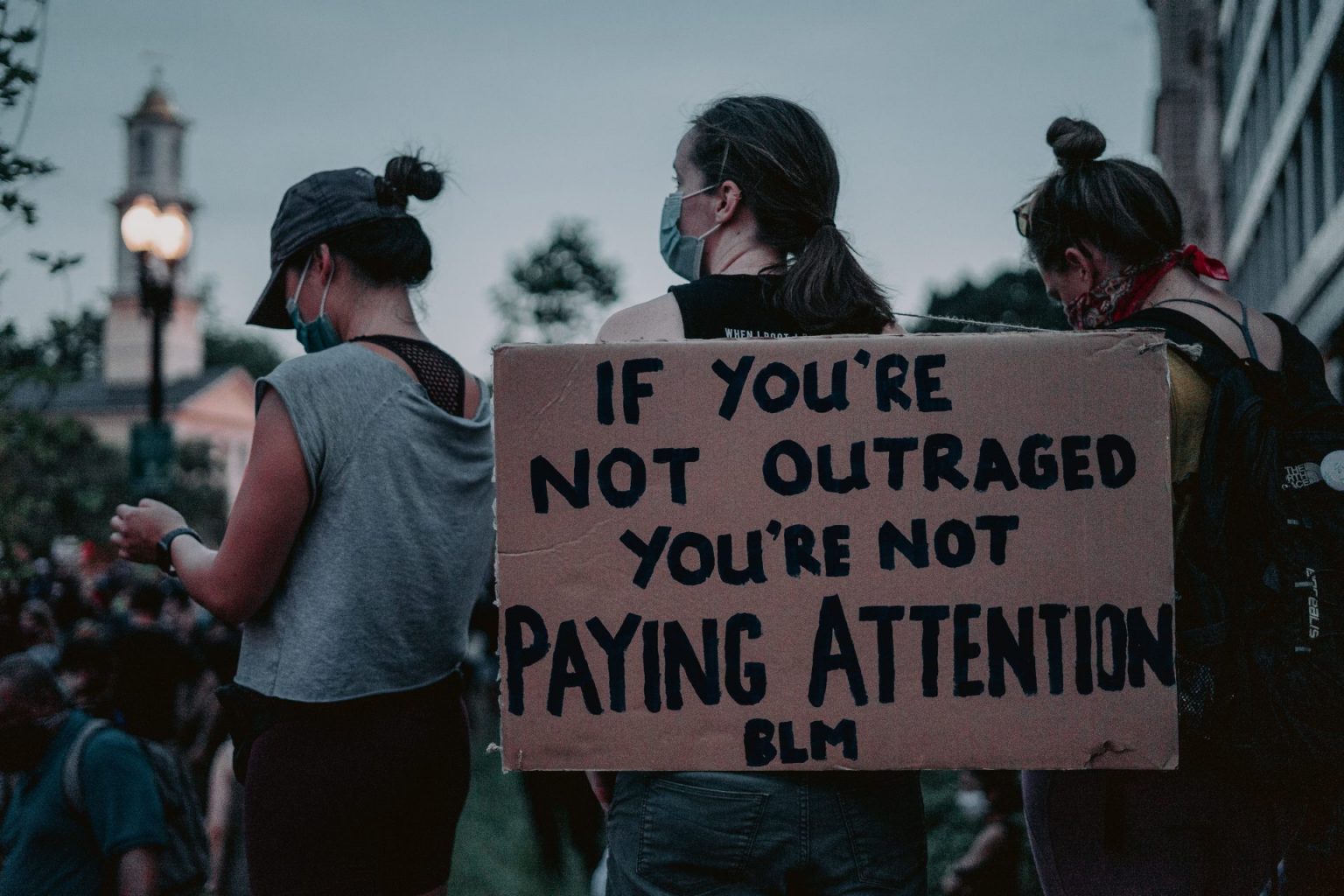 A sign reads 'If you're not outraged you're not paying attention BLM'