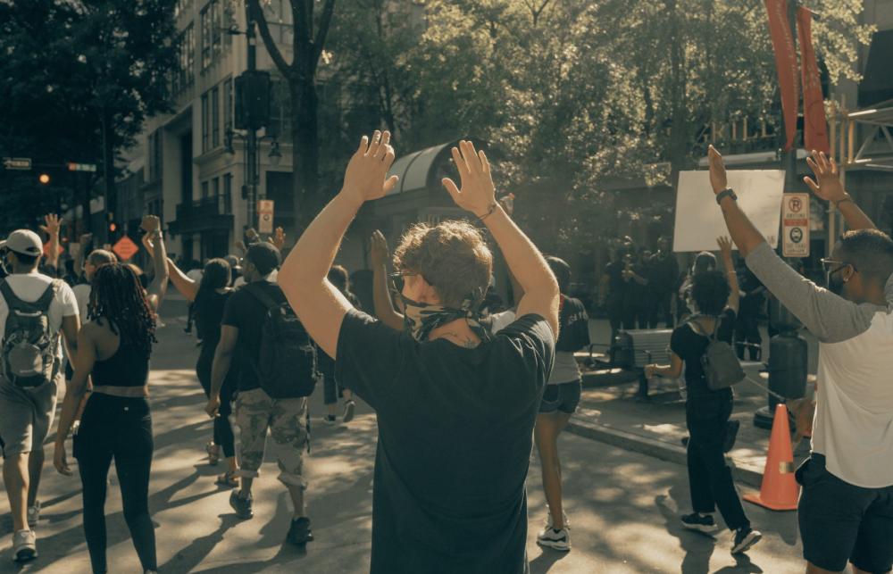 Photo of protesters with hands raised