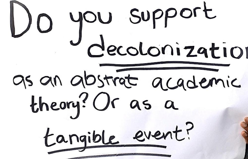 A sign saying: Do you support decolonization as an abstract academic theory? Or as a tangible event?